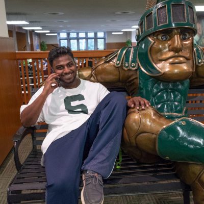 Student Sitting W Sparty Statue Resize