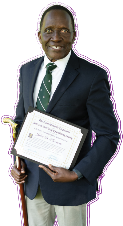 Dr. Kaneene holding award.